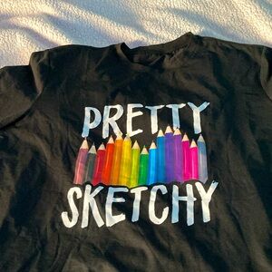Size 1X black t-shirt with colored pencil and “pretty sketchy” on the front